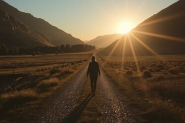 Persona caminando por un valle iluminado por la luz del amanecer representando el mensaje del Salmo 23:4 sobre la protección y compañía de Dios.